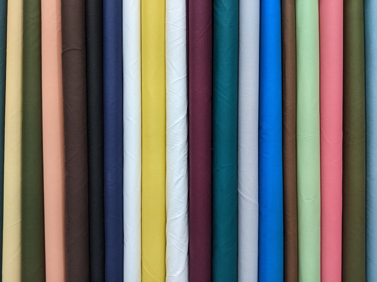 A close-up view of colorful rolled fabrics showcasing a variety of hues and textures.